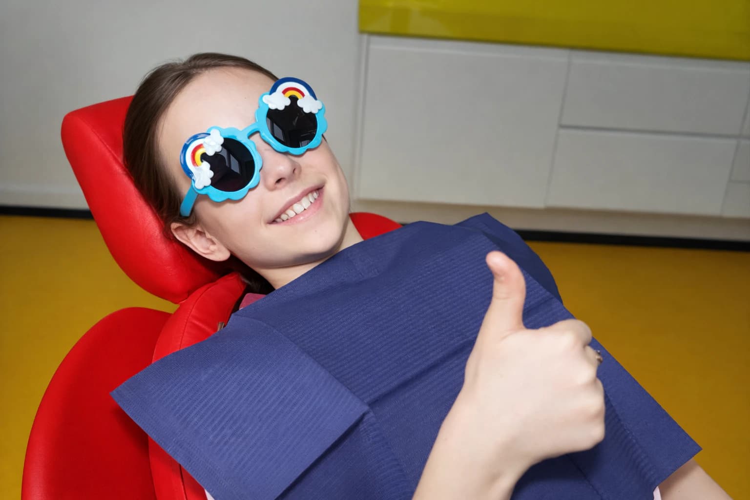 Мальчик в стоматологическом кресле BAMBINO показывает большой палец